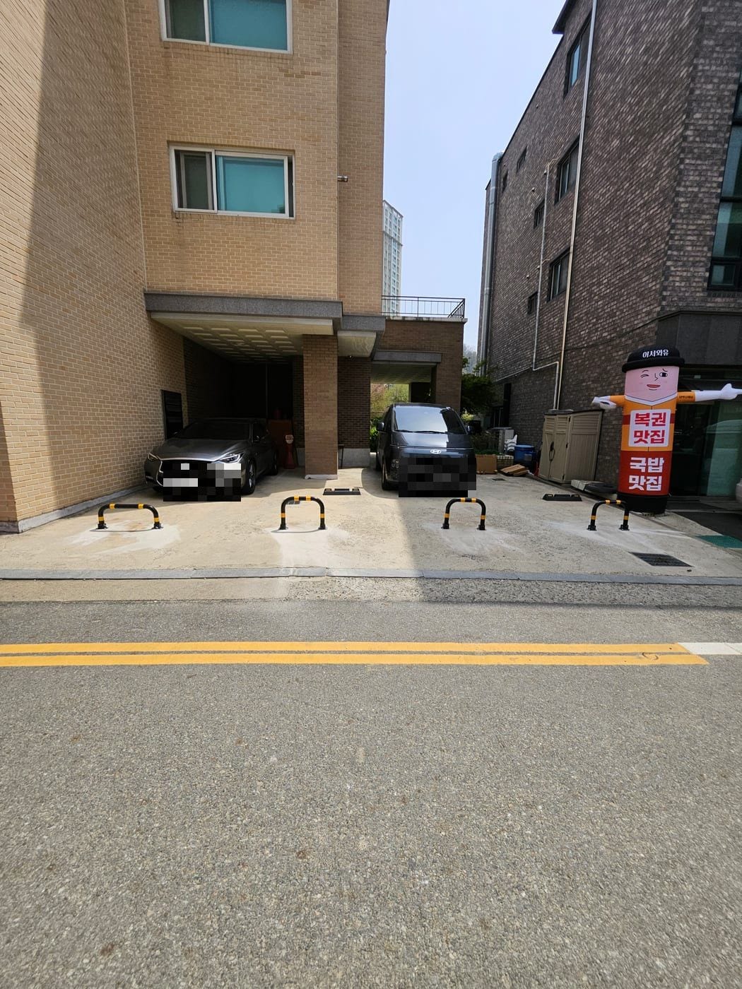 자리마다 새 접이식 볼라드로 교체한 상가 주차장