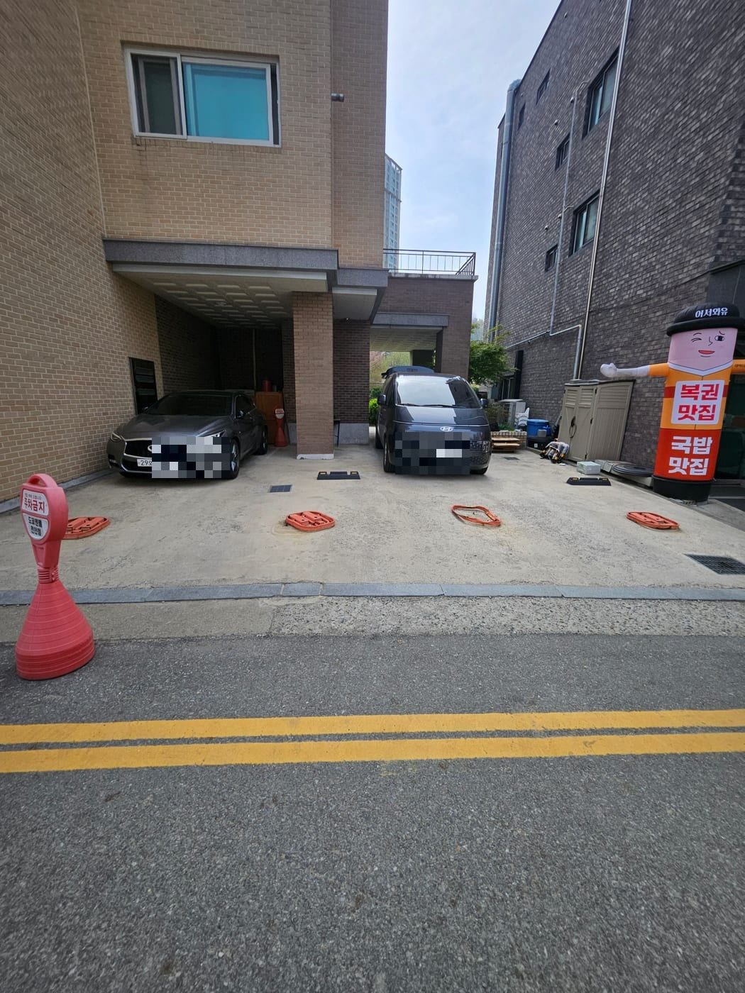 녹슬어 접히지 않는 주황색 접이식 주차차단기가 있던 천안 상가 주차장